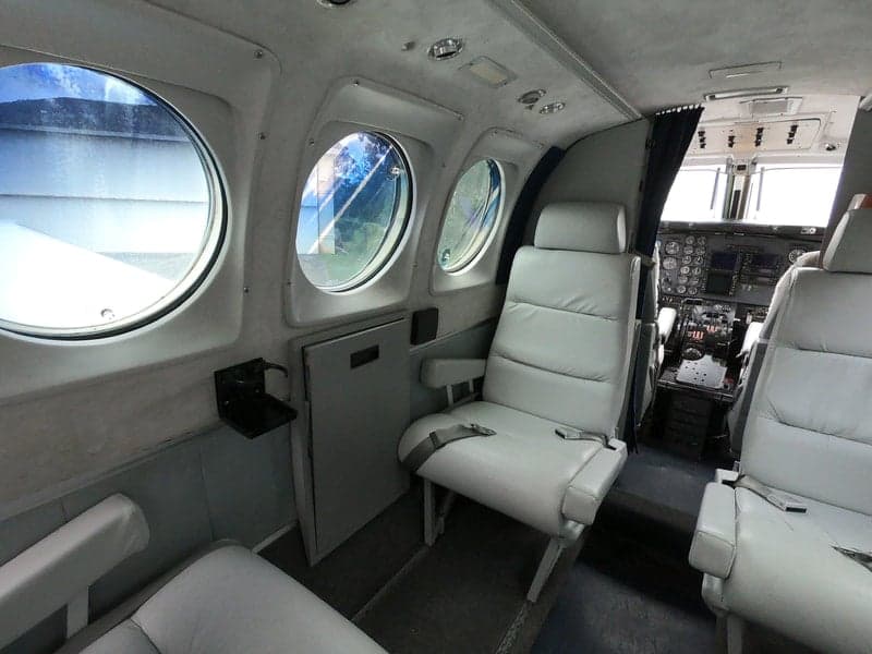 The interior of the Beechcraft King Air 90C, highlighting the seating, windows, and cabin features.