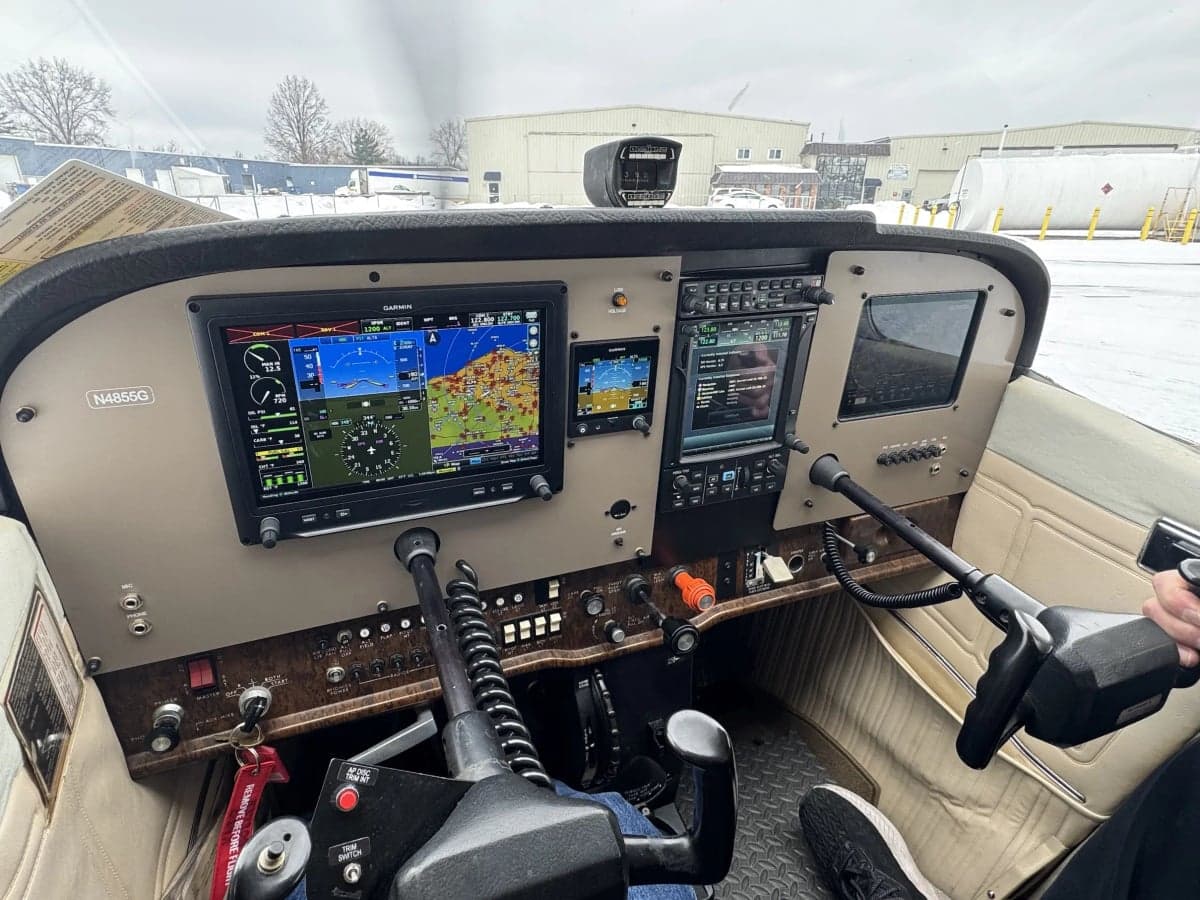 The cockpit of N4855G features a modern glass panel and beige interior.