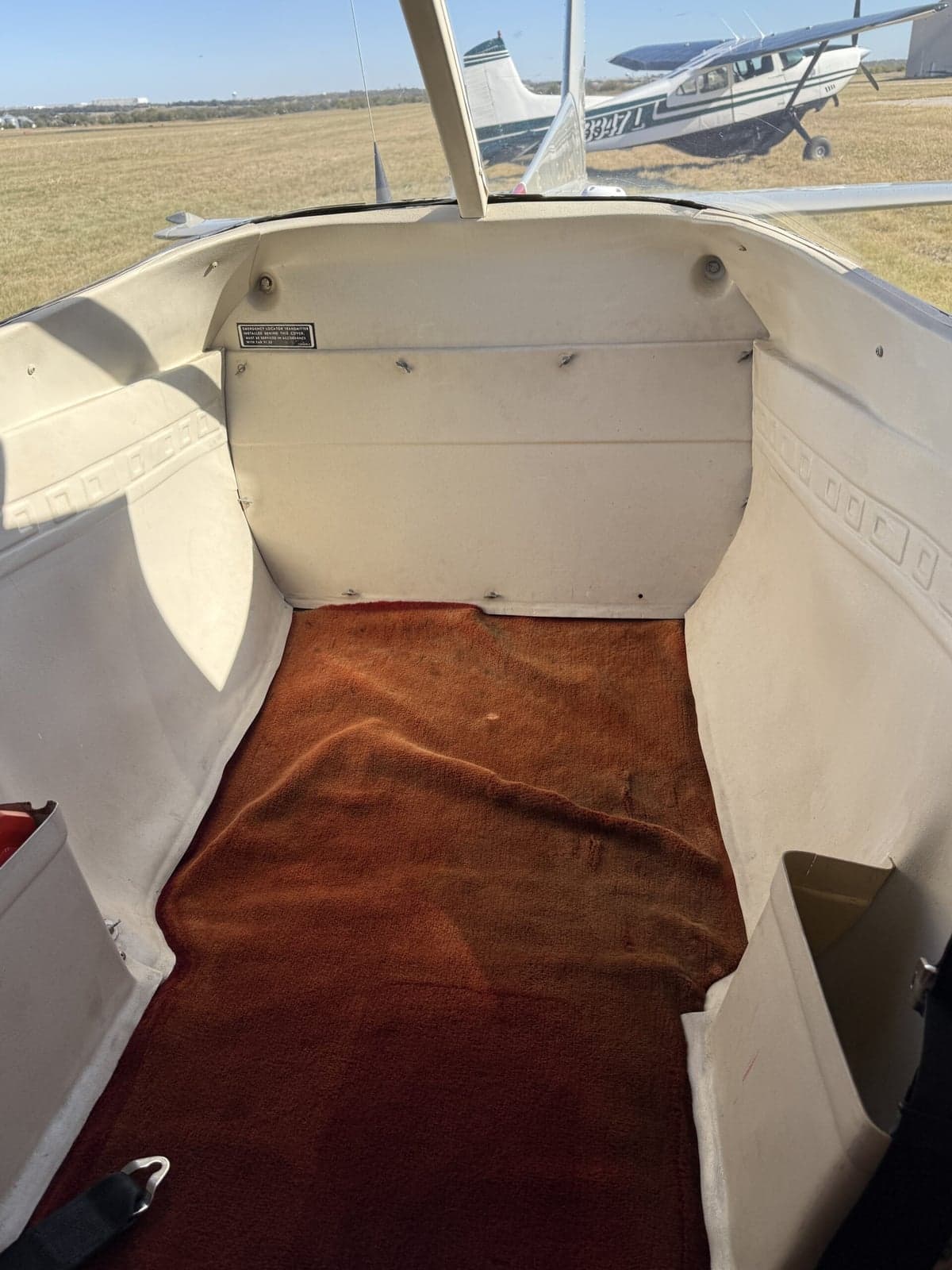 The rear baggage compartment of the Cessna 152 II with red carpet.