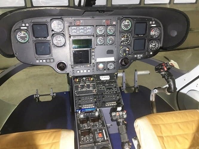The instrument panel and controls of a helicopter cockpit.
