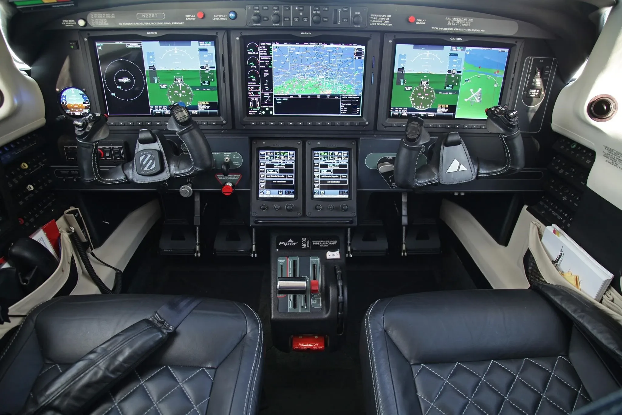 The cockpit of a Piper M600 aircraft, featuring a modern Garmin G1000 NXi avionics suite with multiple large displays.