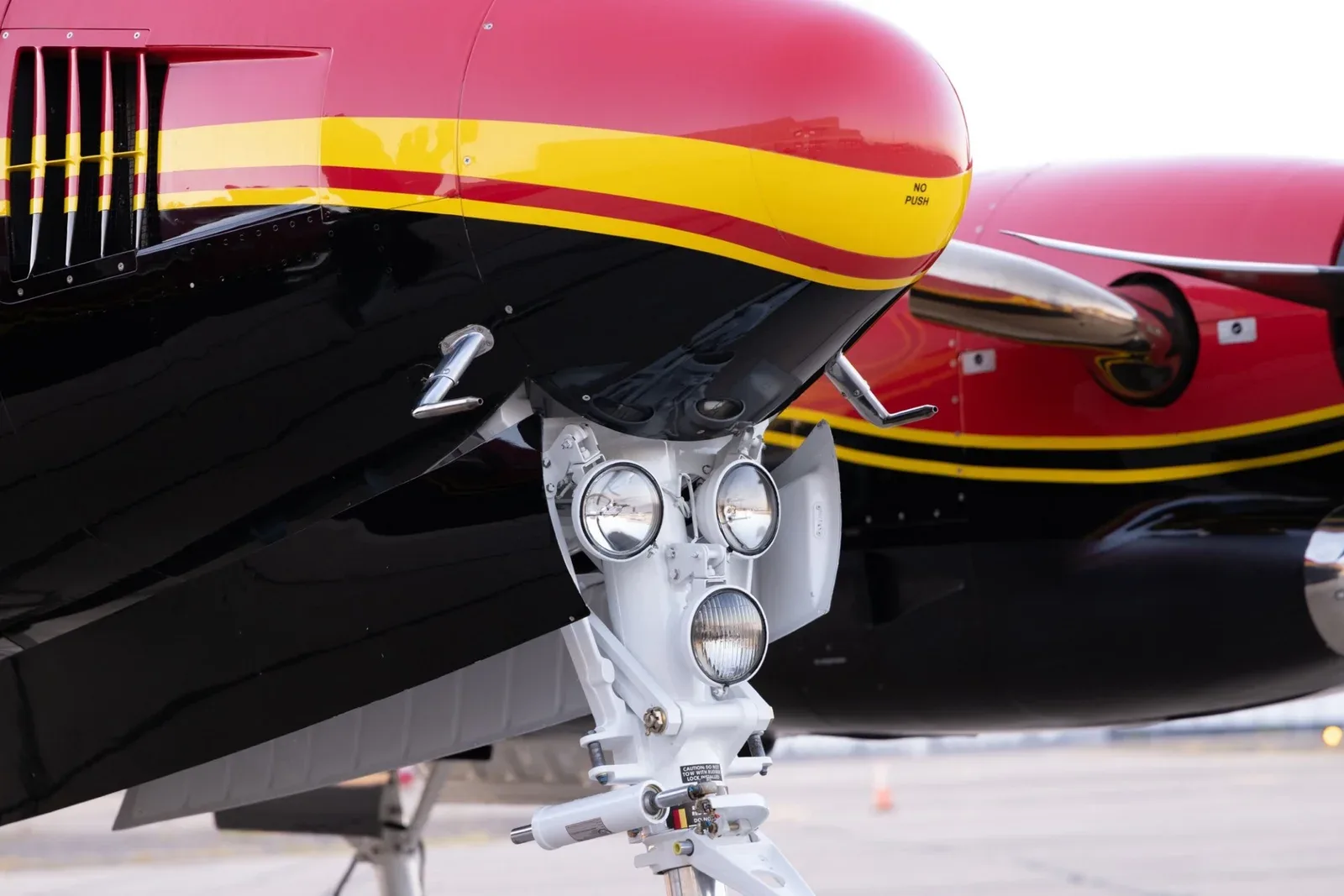 A close-up view of the nose landing gear and lights of the King Air C90B.