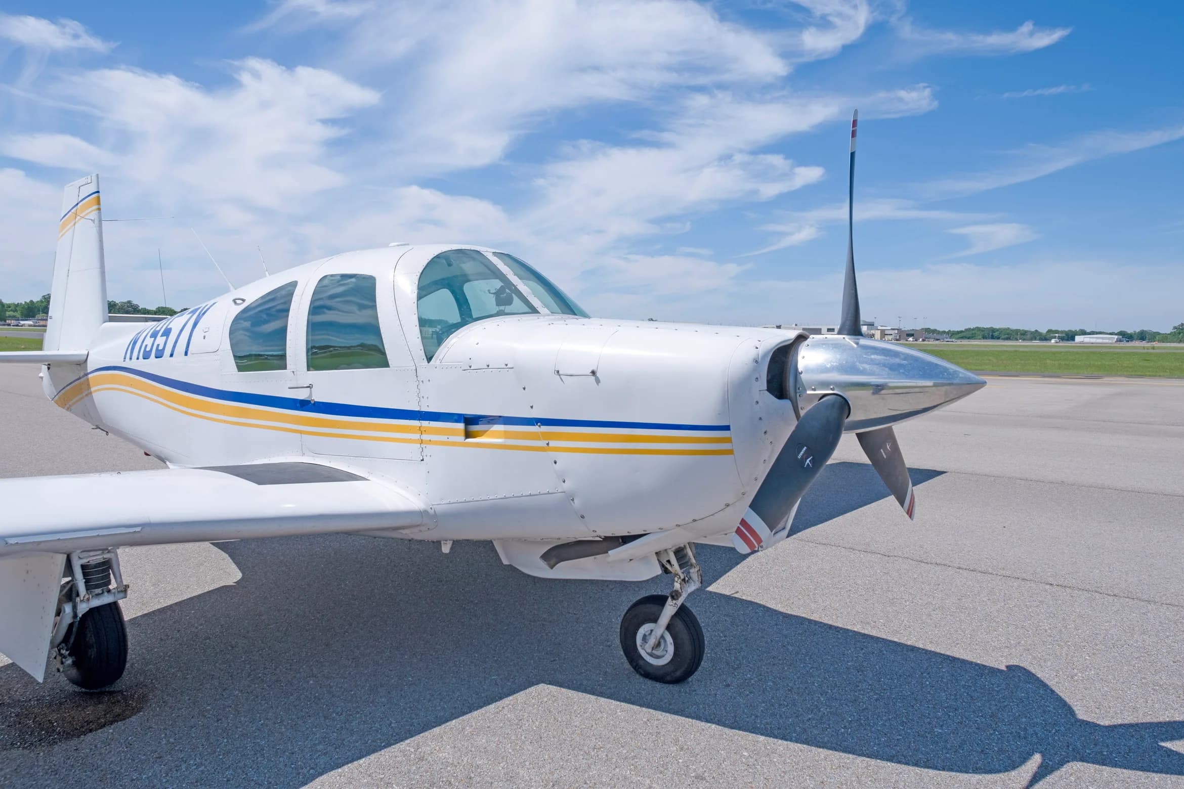 A close-up front-side view of the propeller and cockpit area of a white single-engine aircraft, registration N1957Y.