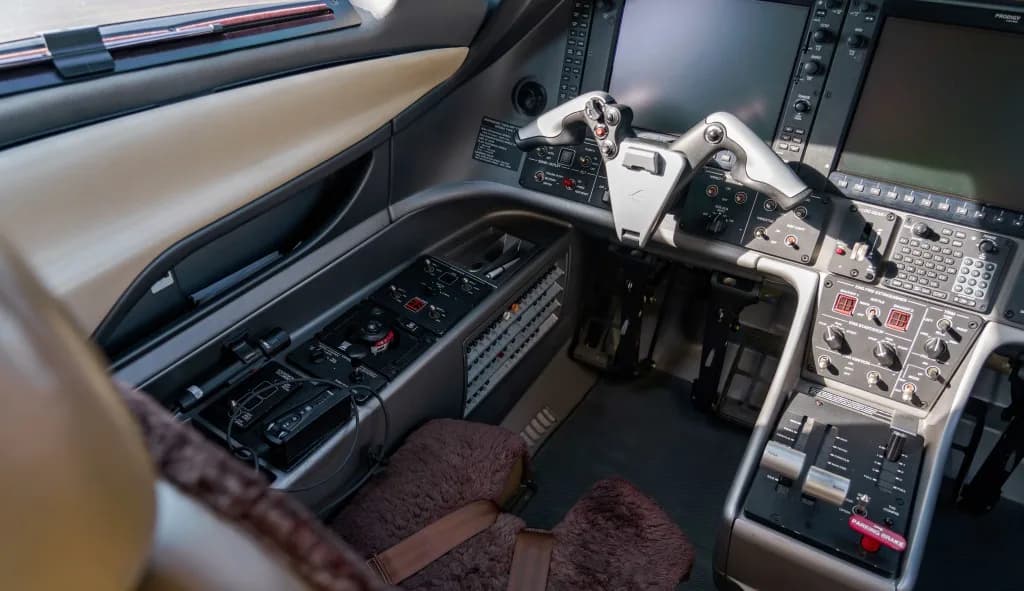 A close-up view of the right side of a modern aircraft cockpit with flight controls and instrument panels.