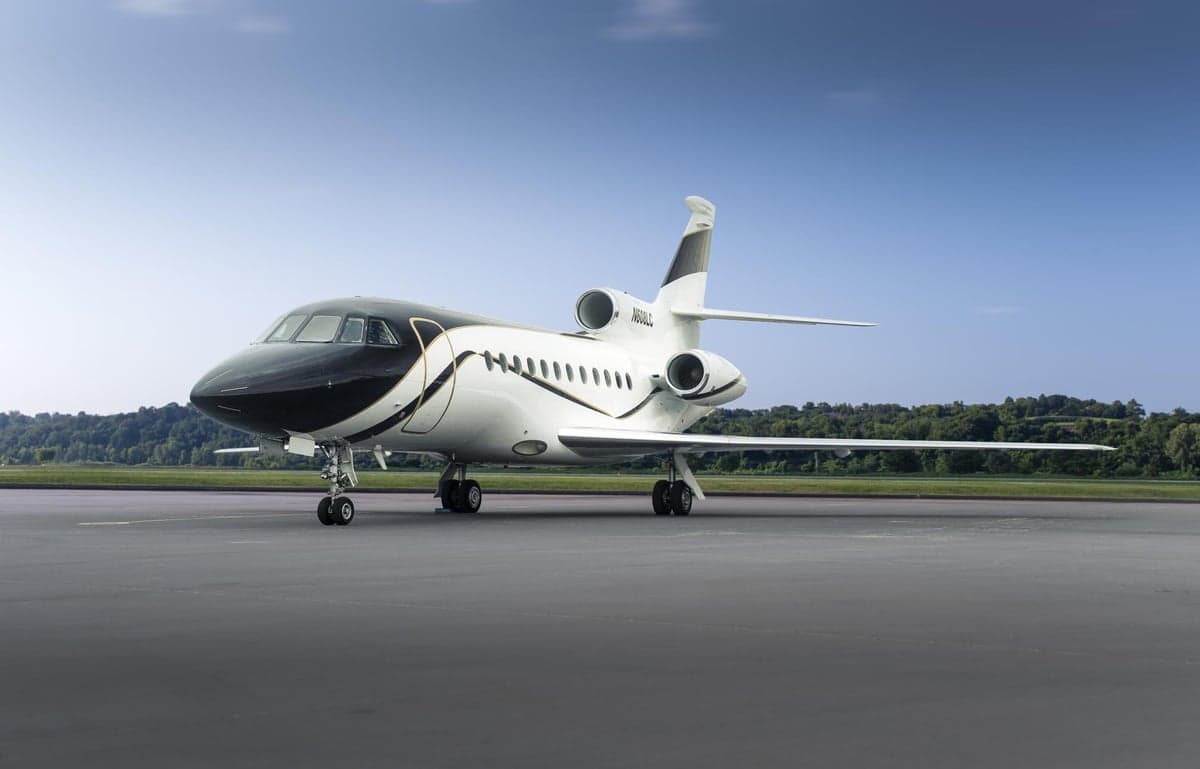 A Falcon aircraft with registration N608LC is parked on the tarmac.