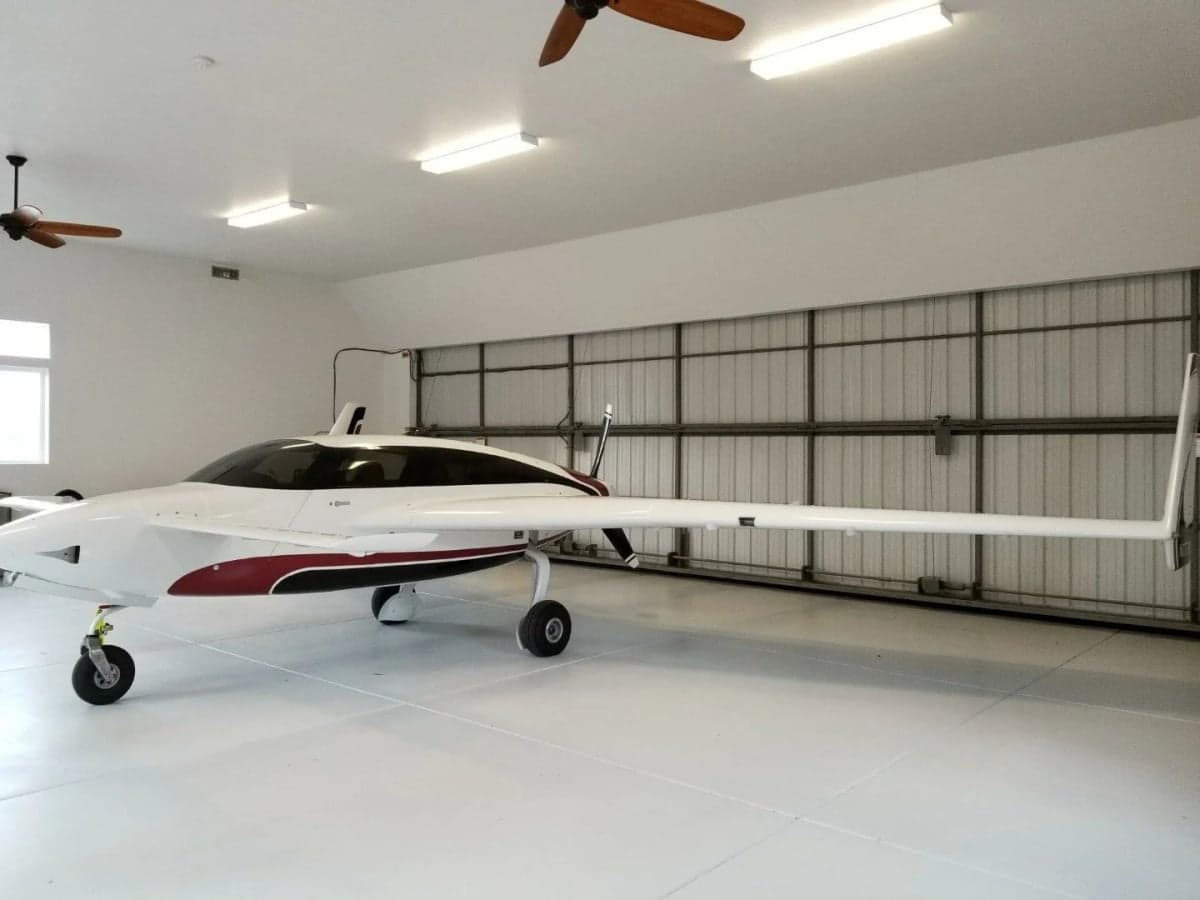 Side view of N7779X aircraft inside a hangar.
