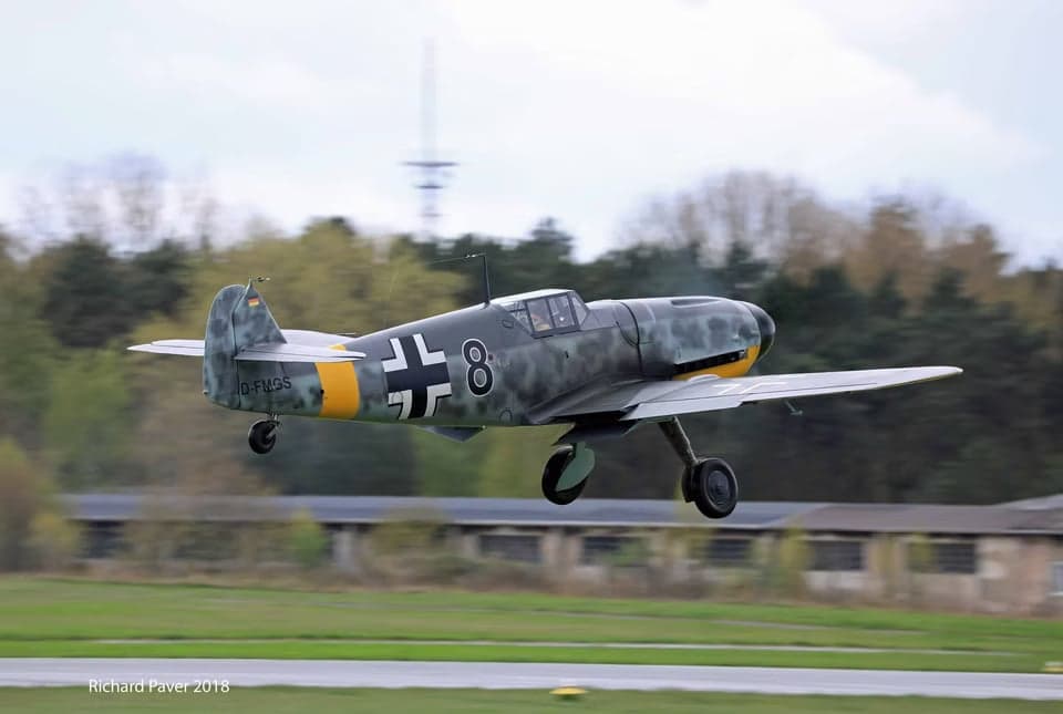 Messerschmitt Bf 109 taxiing on a grassy runway.