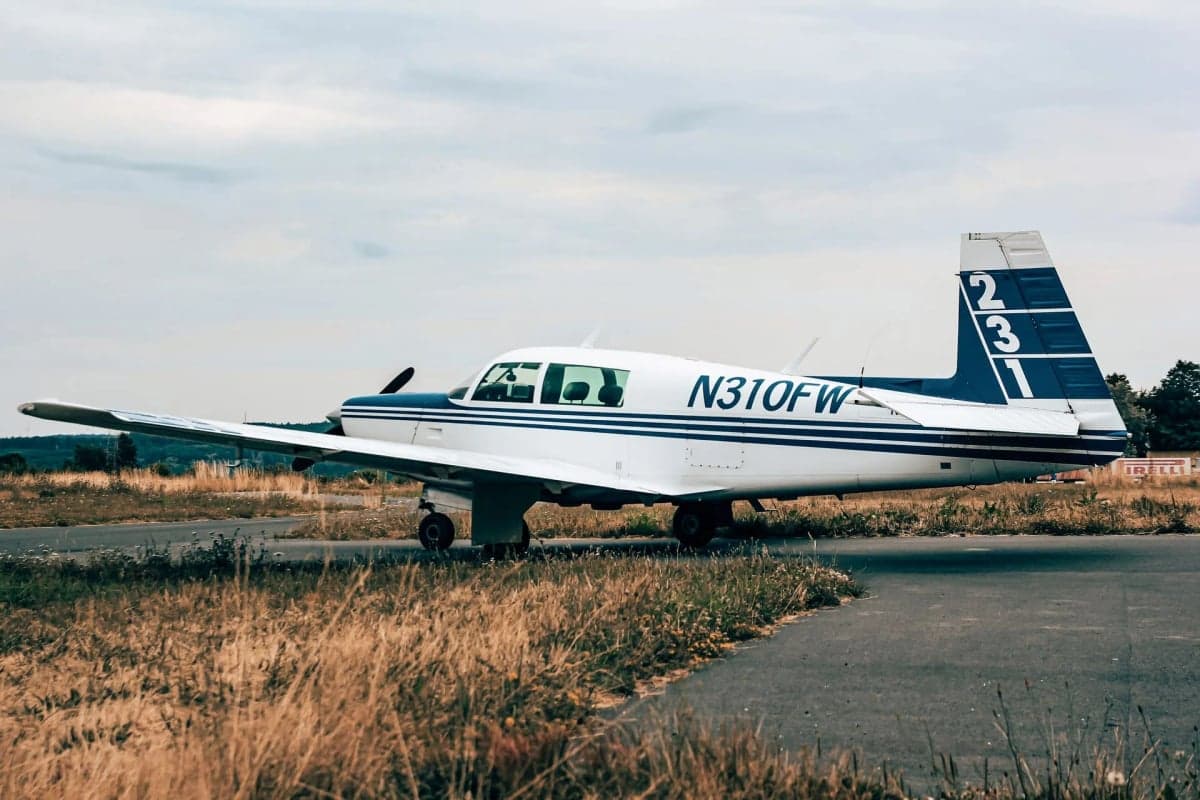 N310FW parked in front of a wooden hangar.