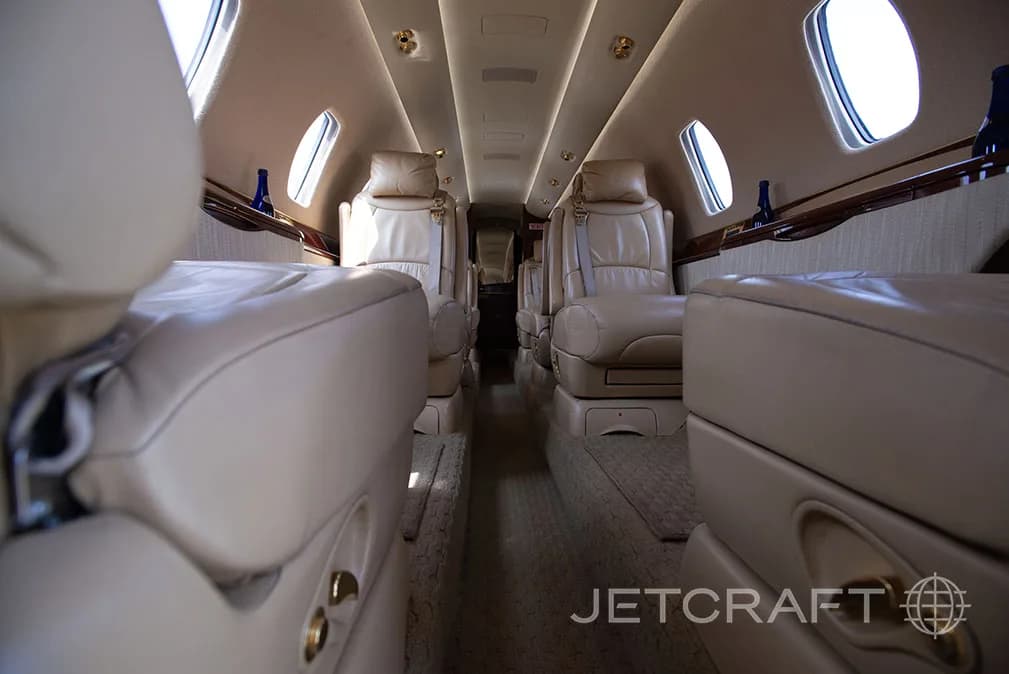The interior of a jet with leather seats and carpeted floor.