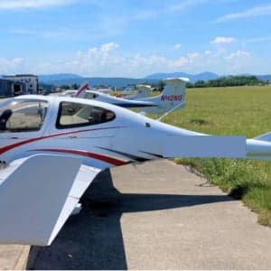 Diamond DA40 aircraft with red and white paint scheme on the tarmac.