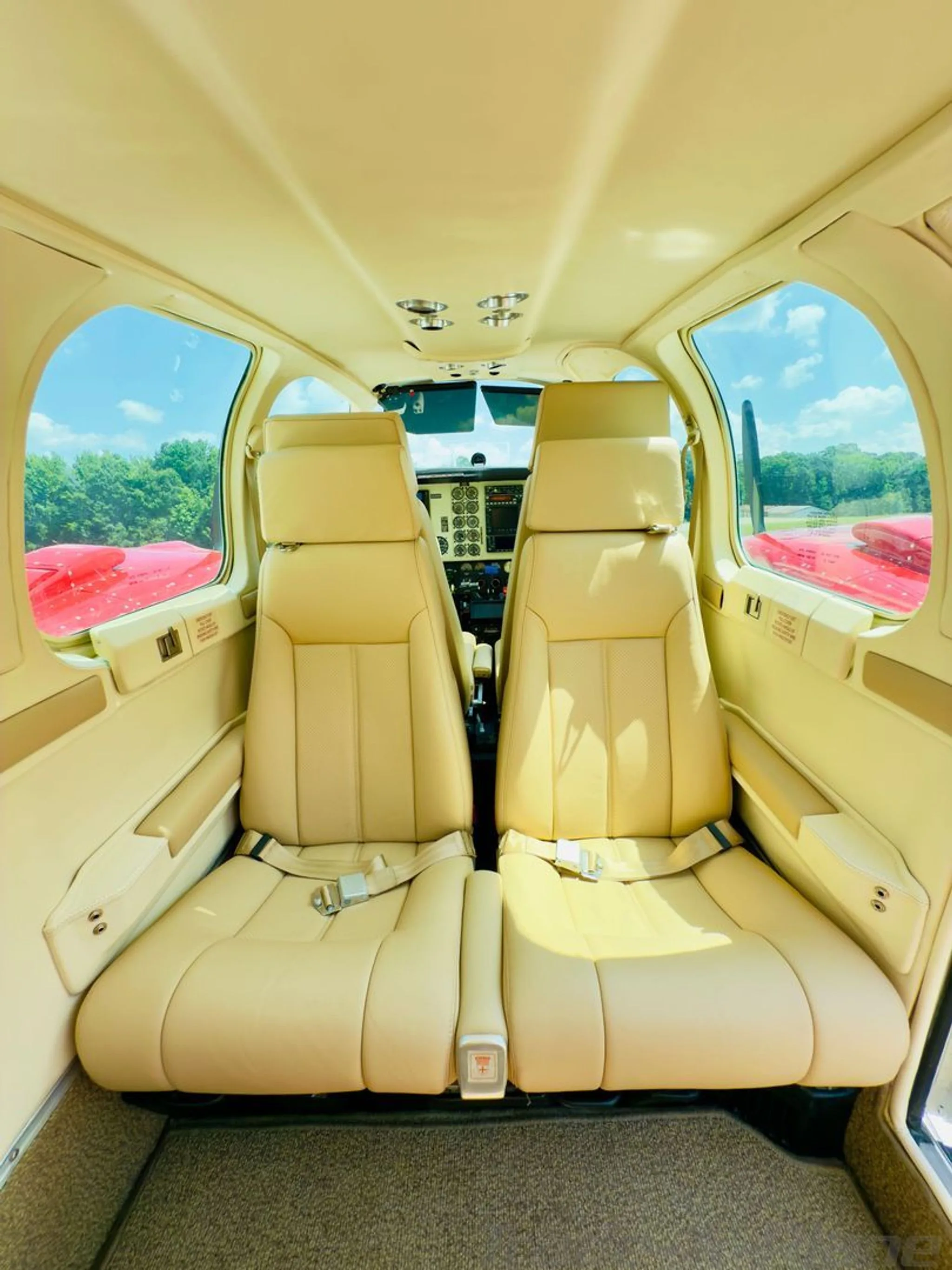 View from the rear cabin looking forward, showing the beige leather seats and a glimpse of the cockpit.