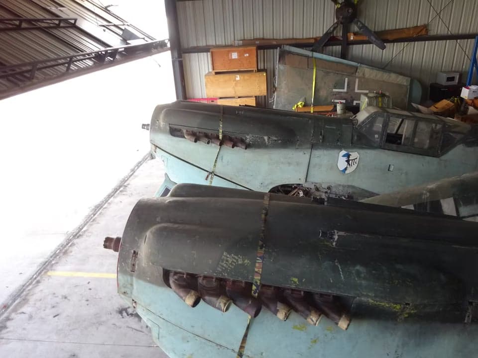 A disassembled Messerschmitt Bf 109 aircraft in a hangar, showing the engine and fuselage.
