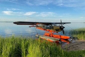 A float plane is docked near the shore.