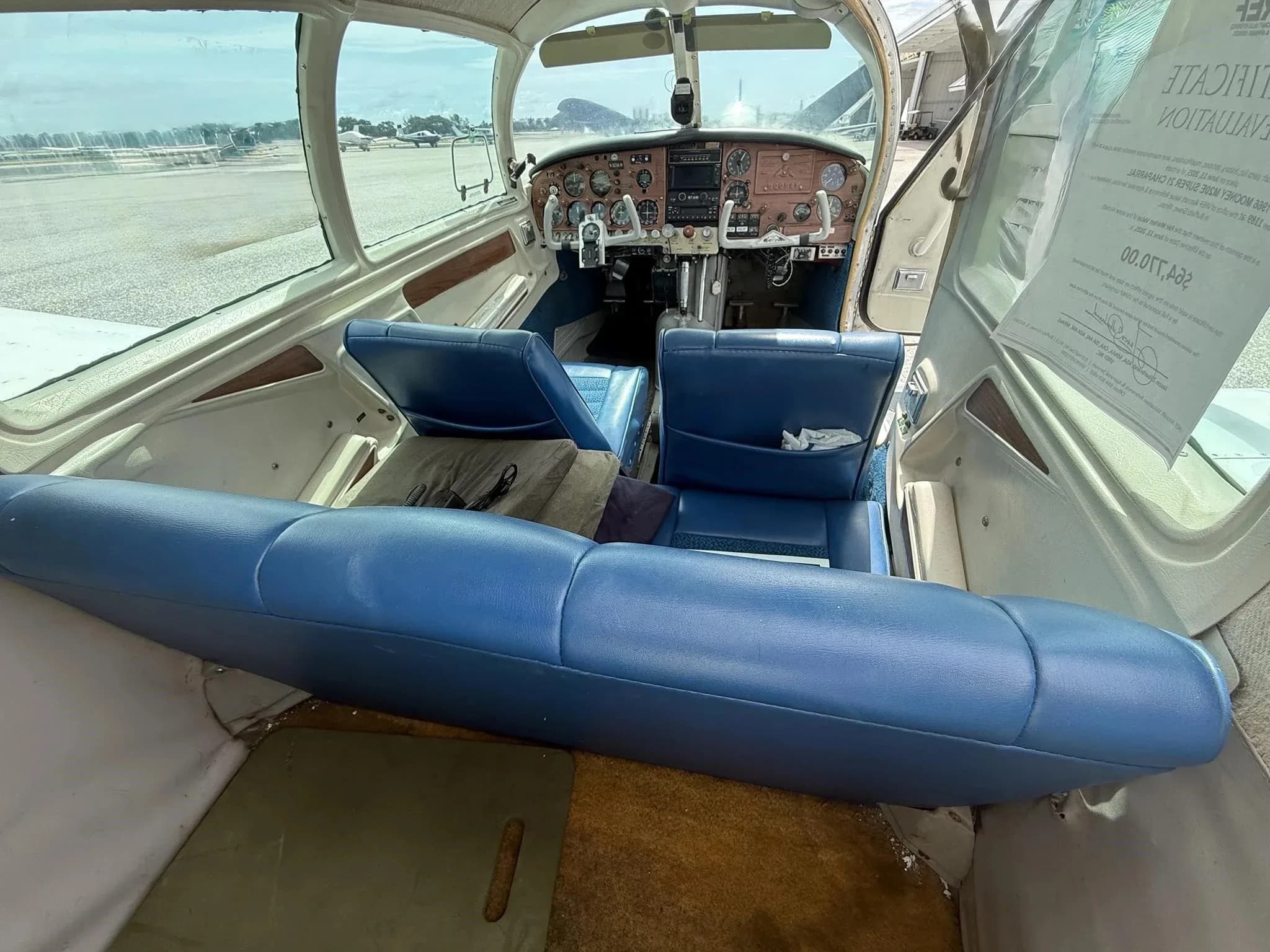 The aircraft's blue interior cabin, looking forward towards the cockpit and instrument panel.