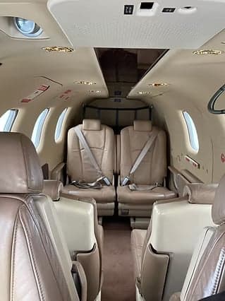 Aircraft cabin with tan leather seats.