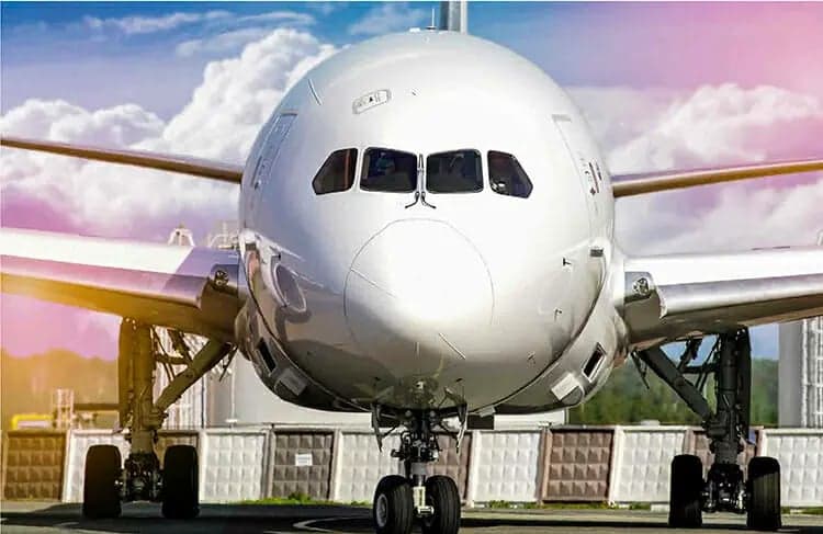 Front view of a white passenger jet on the tarmac.