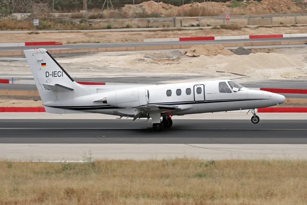 A Cessna Citation Mustang aircraft, registration D-IECI, landing on a runway.