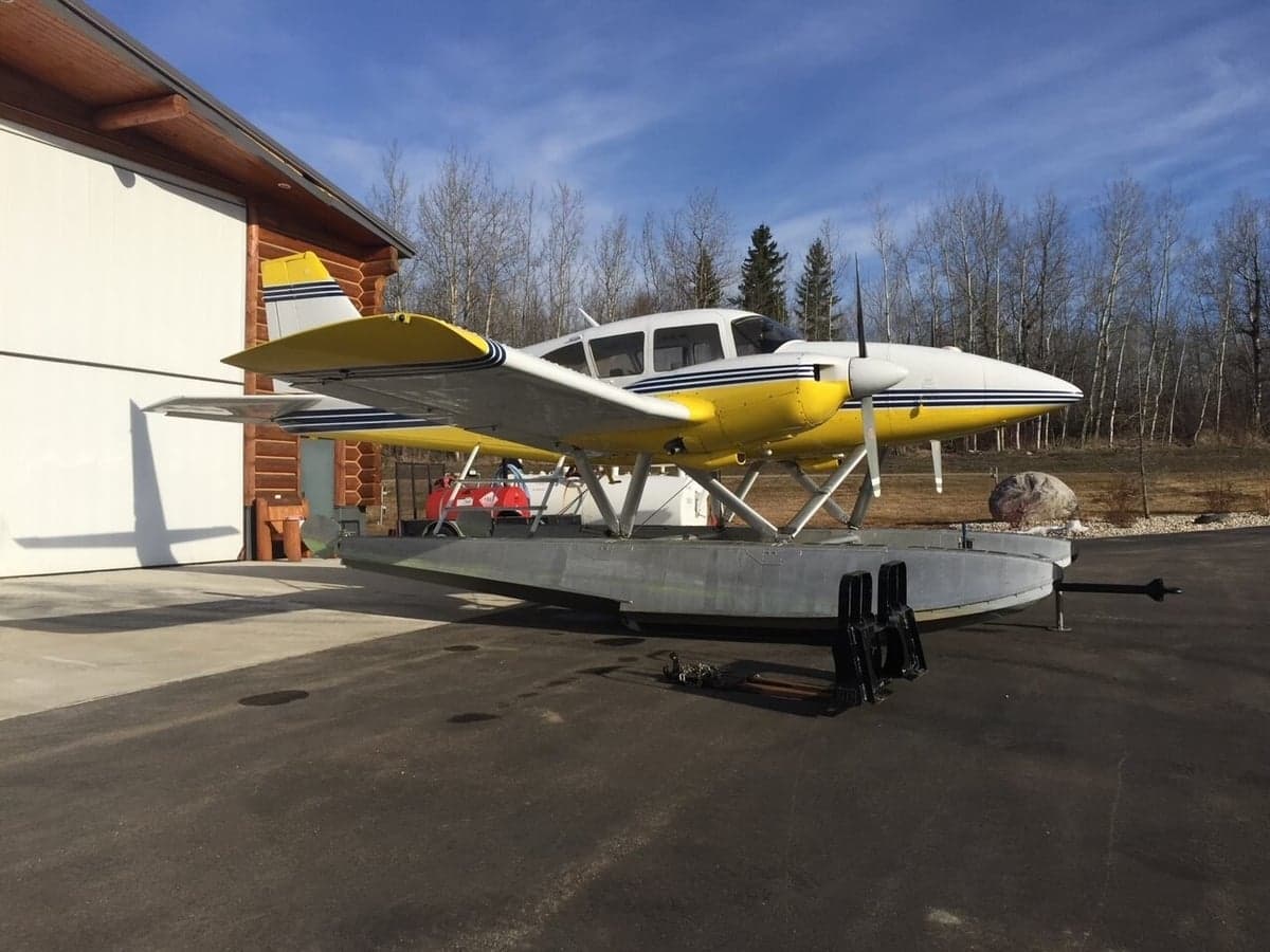 Underside view of the yellow and white twin engine aircraft on floats.