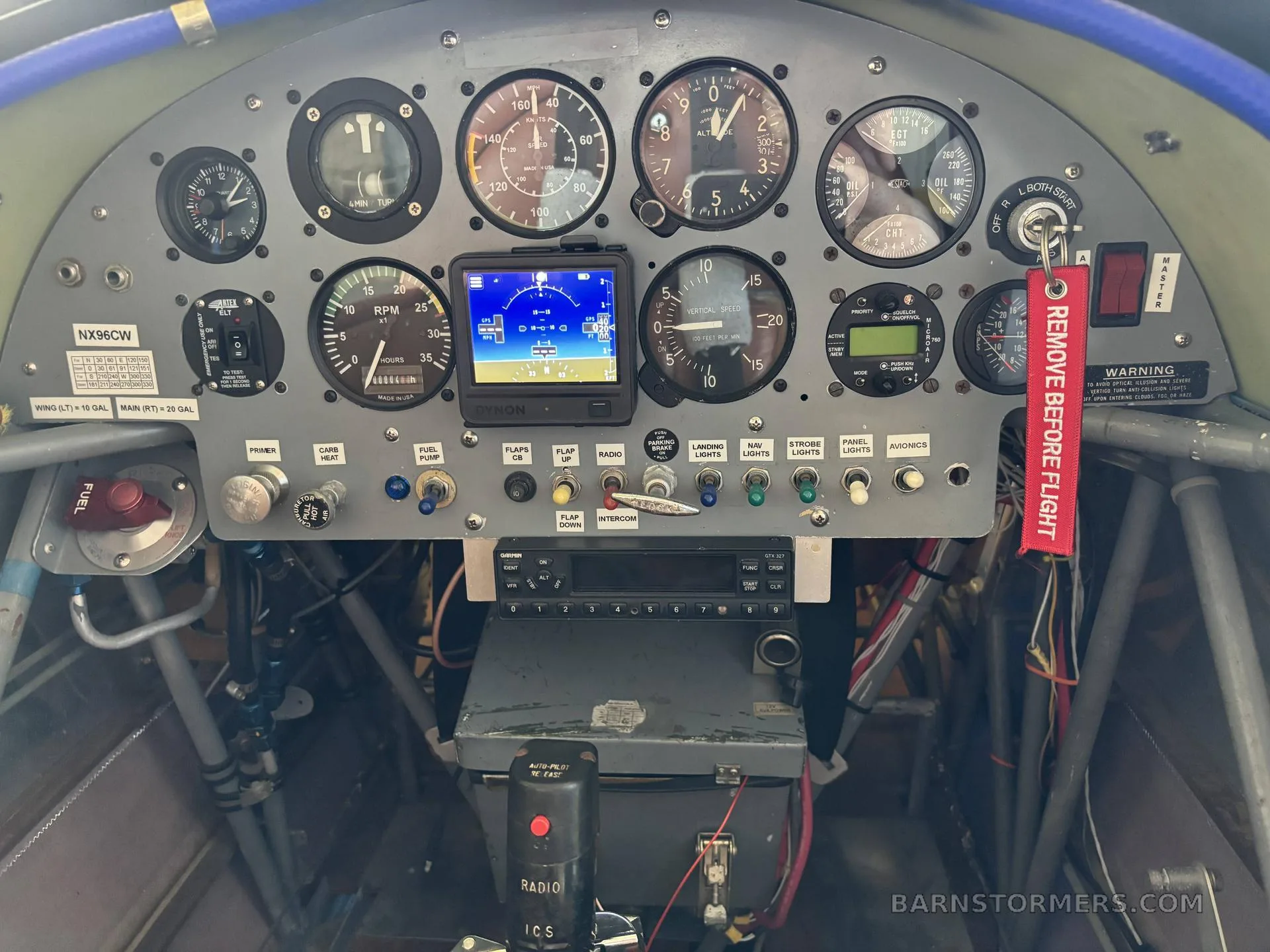 A close-up view of the aircraft's instrument panel with various gauges, a digital display, and a 'REMOVE BEFORE FLIGHT' tag.