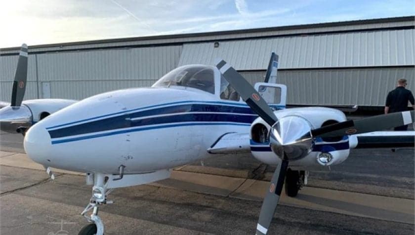 Close up of the nose of a Beechcraft Baron with a white and blue paint scheme.