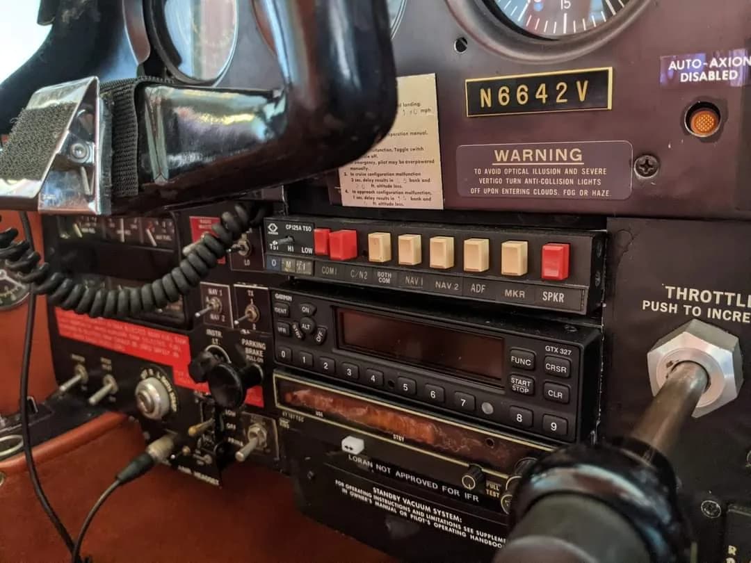 A close-up view of the avionics stack and warning labels in the cockpit of a Bellanca aircraft.