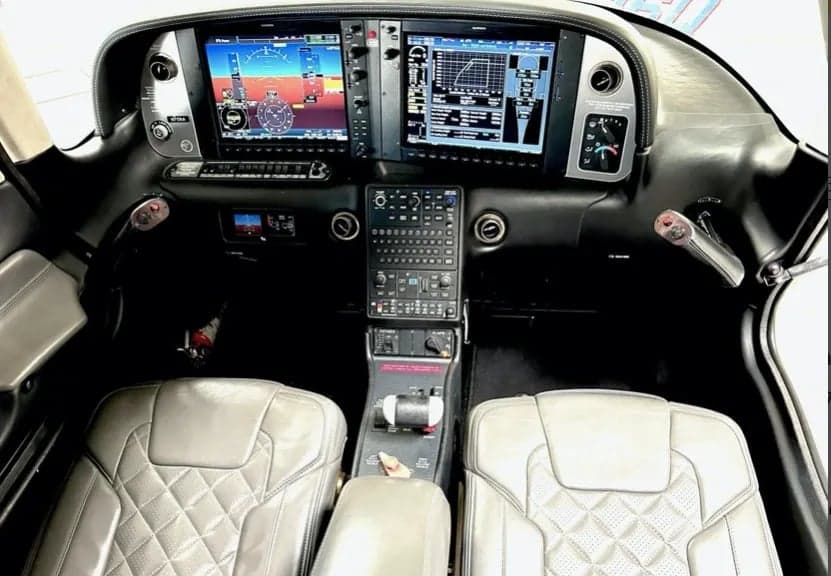 View of the cockpit showing the instrument panel and front seats.