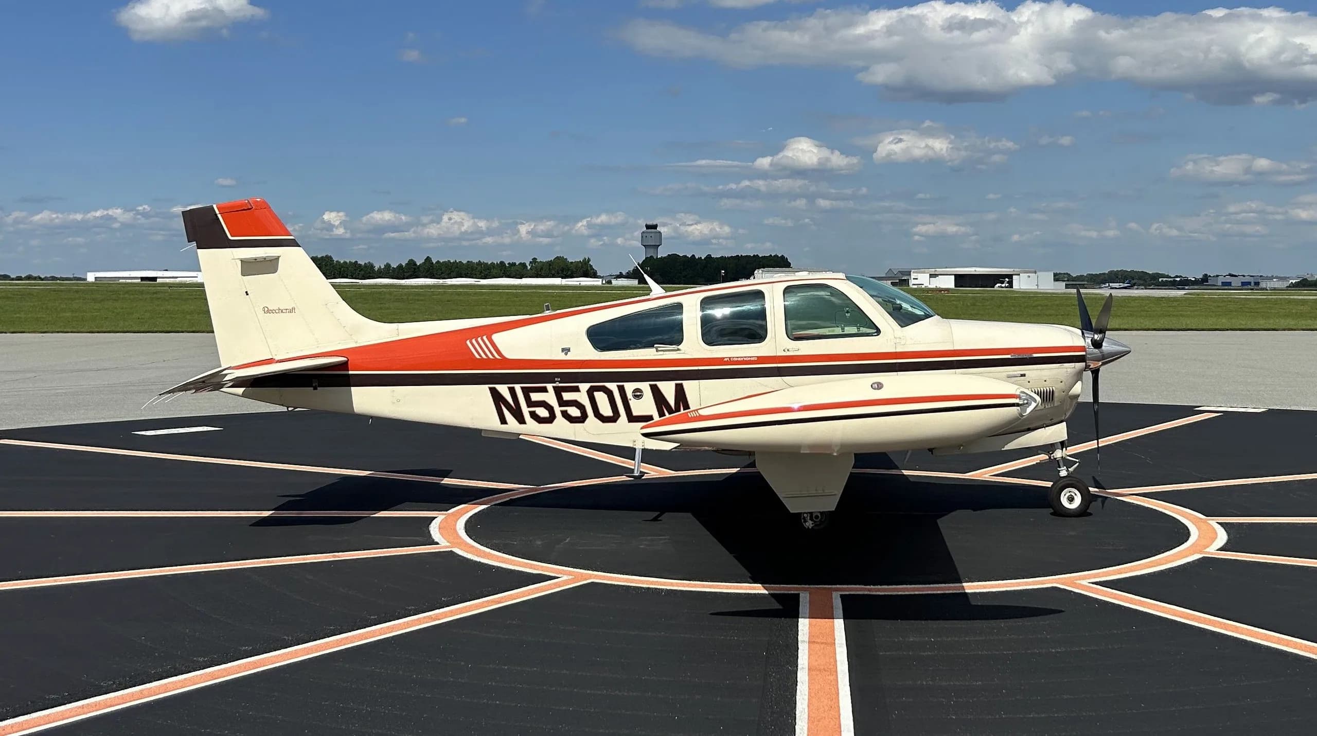 Beechcraft Baron on the tarmac with white and orange paint scheme.