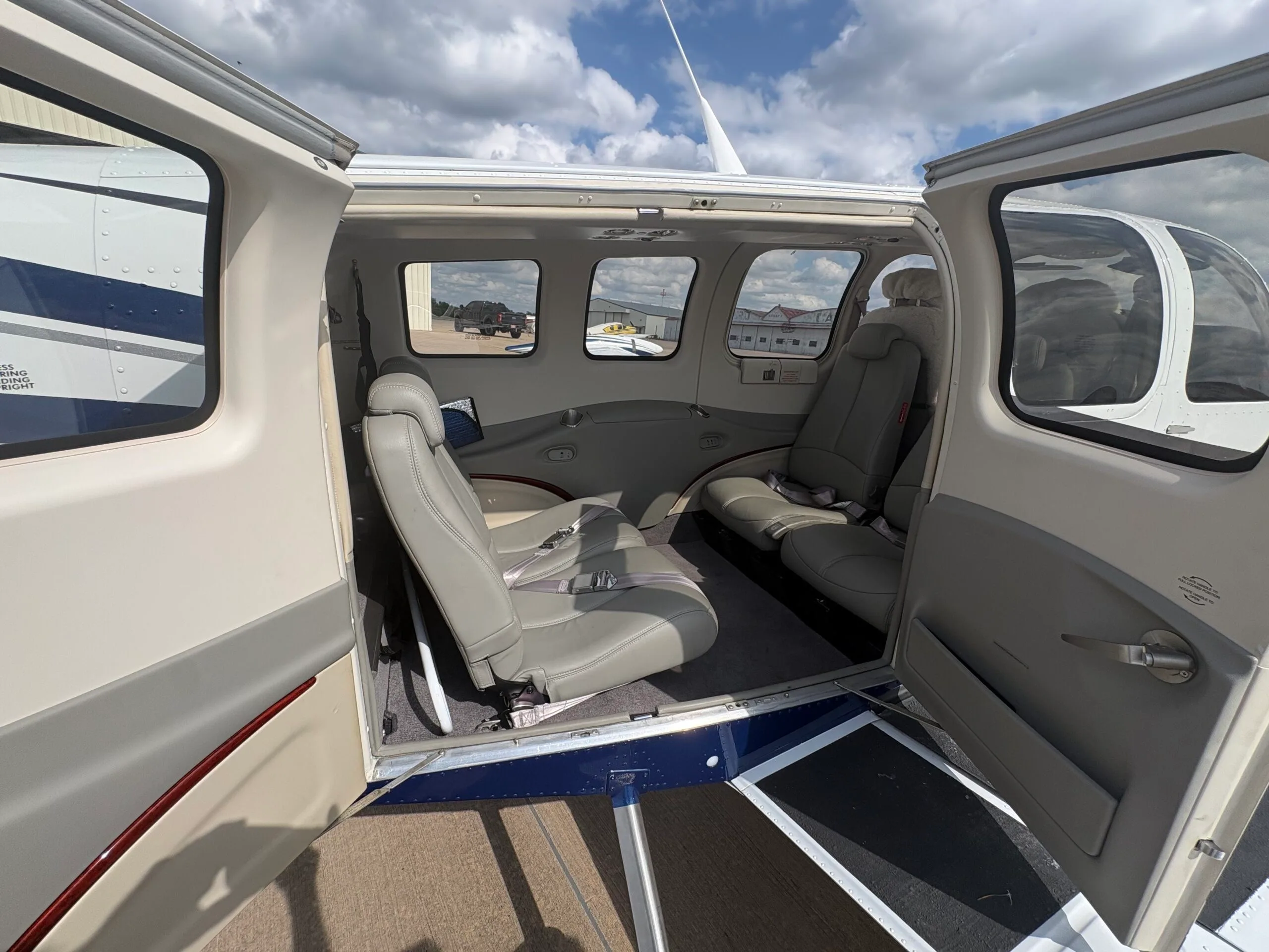 The open cabin door of the Beechcraft Bonanza N686AG, revealing the light gray passenger seats.