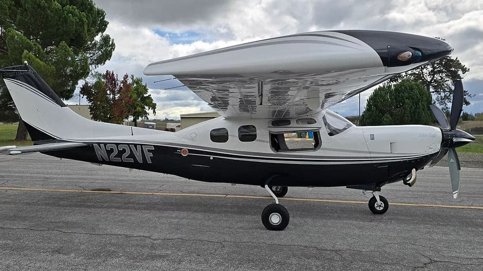 A black and white Cessna 208B Grand Caravan, registration N22VF, is parked on the tarmac.