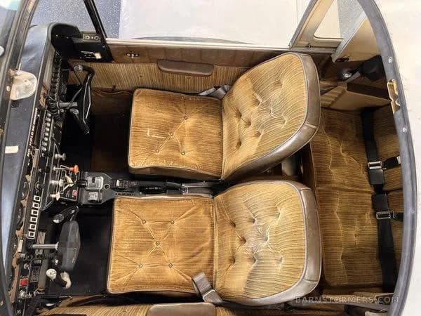 An overhead view of the aircraft's interior, showing two tan upholstered front seats and the floor area.