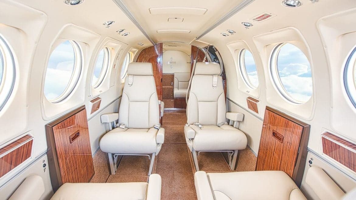Aircraft interior with leather seats and wood trim.
