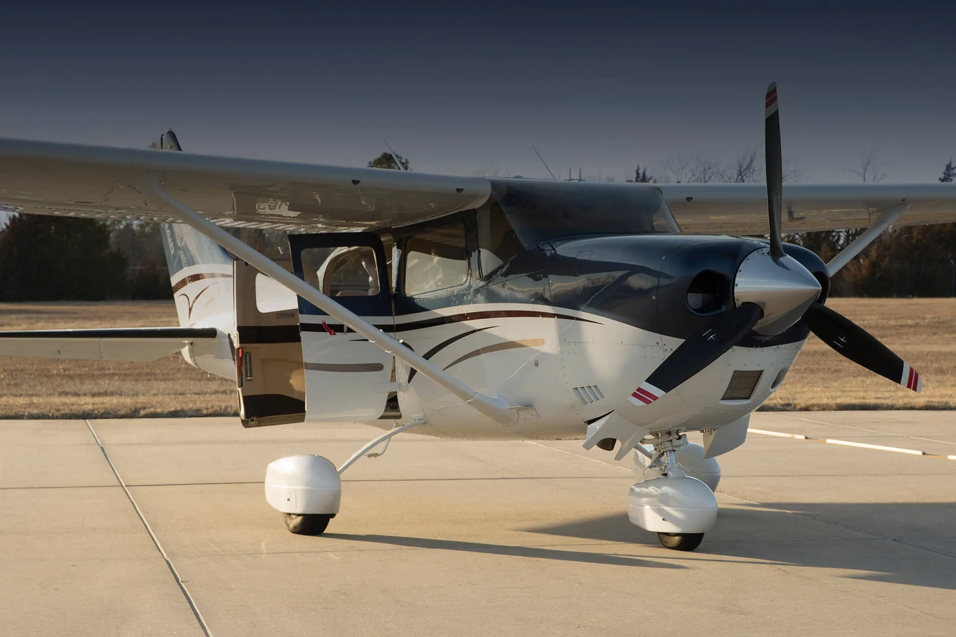 A Cessna Stationair parked on the tarmac with the door open.