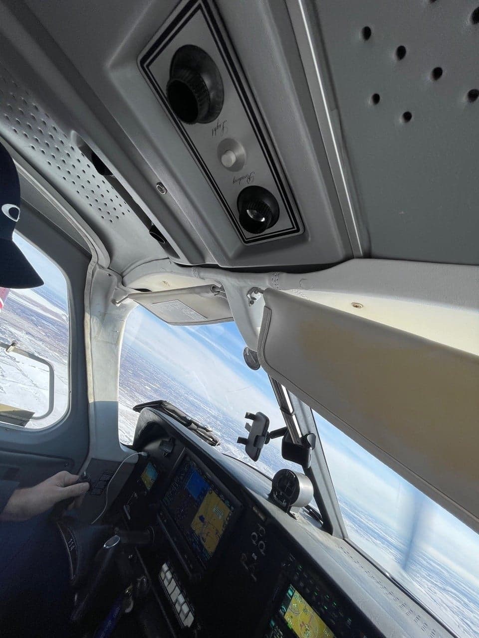 View from the cockpit during flight, showing the instrument panel and outside scenery.