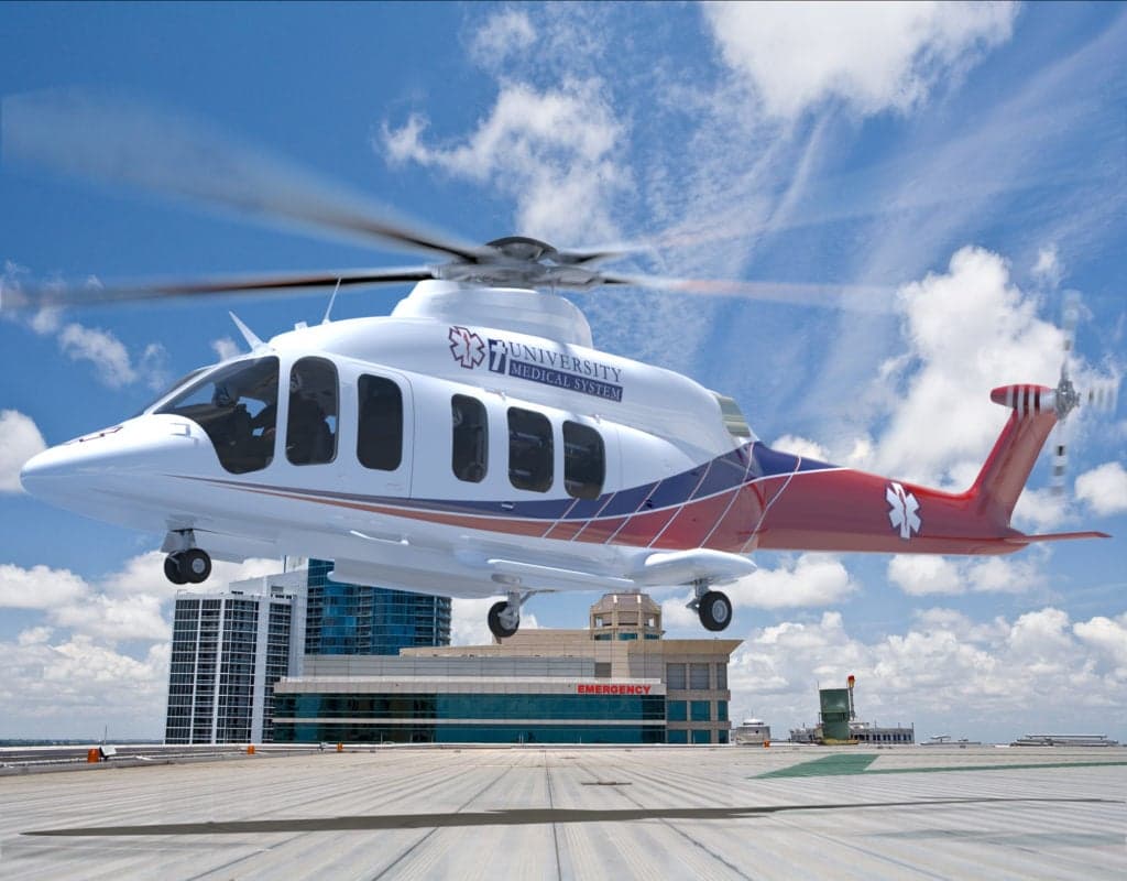 A white and red Bell 525 helicopter with University Medical System livery landing on a helipad.
