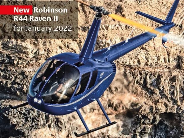 A dark blue Robinson R44 Raven II helicopter flying close to a rocky cliff face.