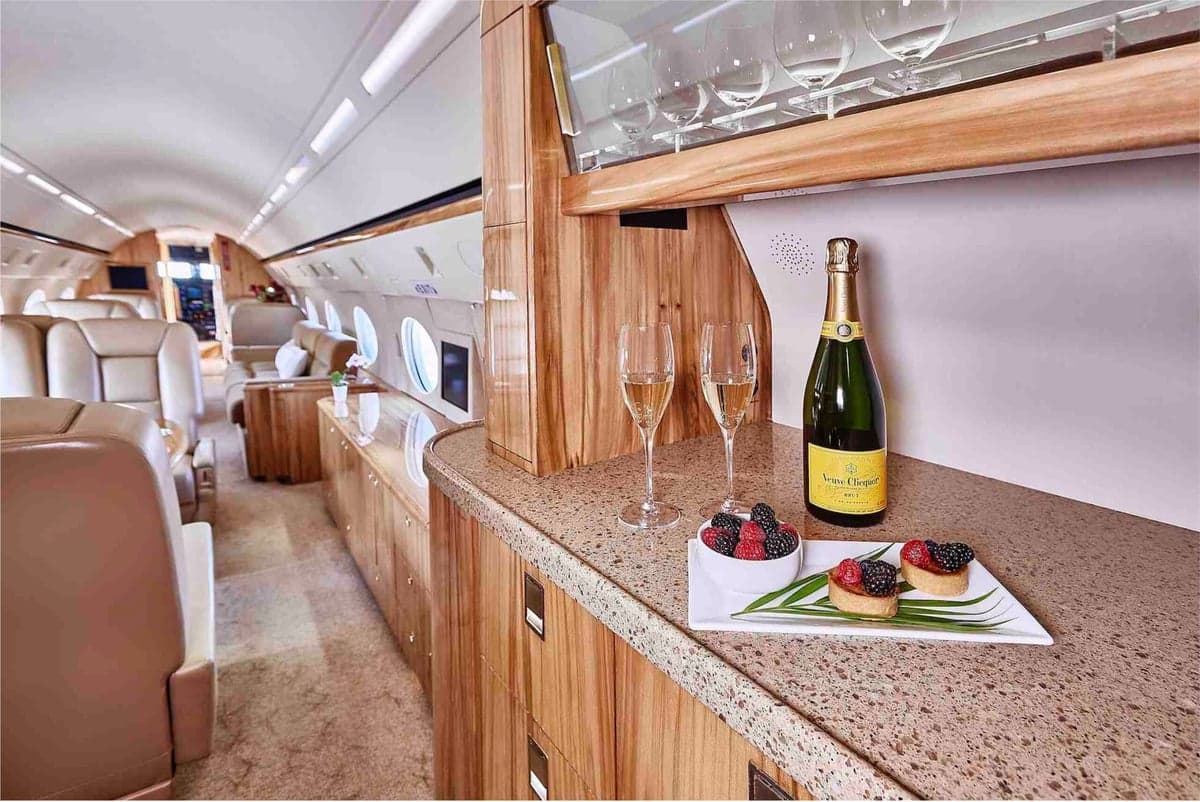 View of the aircraft interior with a bottle of champagne and snacks.