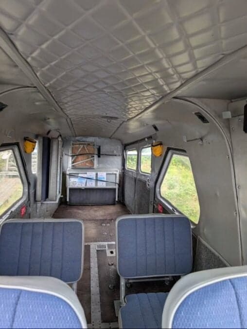 The interior cabin of a de Havilland Beaver floatplane with blue seats.