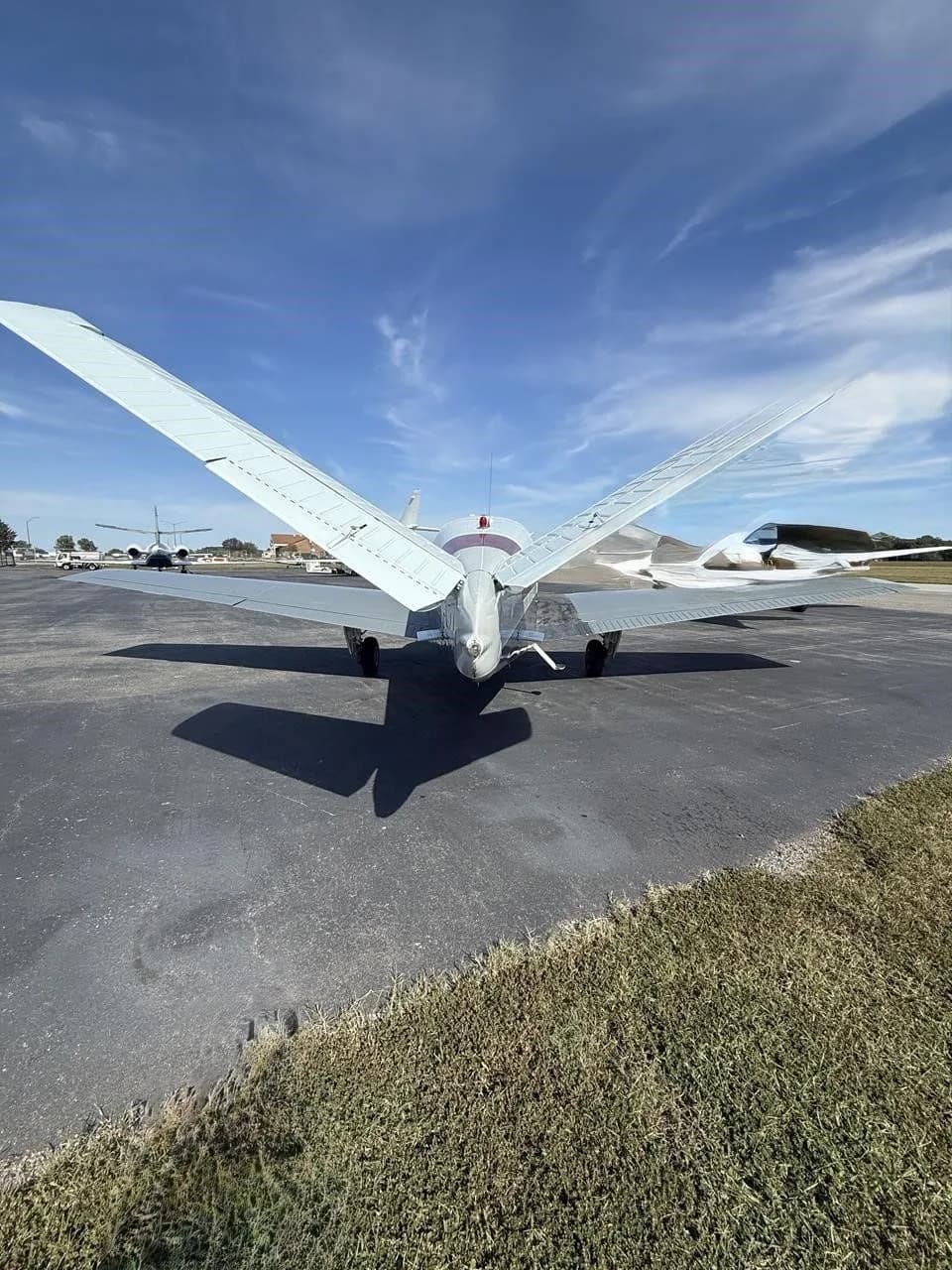 Rear view of the N2194D Beechcraft Bonanza V-tail aircraft, showing its distinctive V-tail on an airfield.