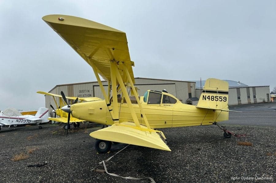 A yellow biplane aircraft with tail number N48559 parked on the ground.