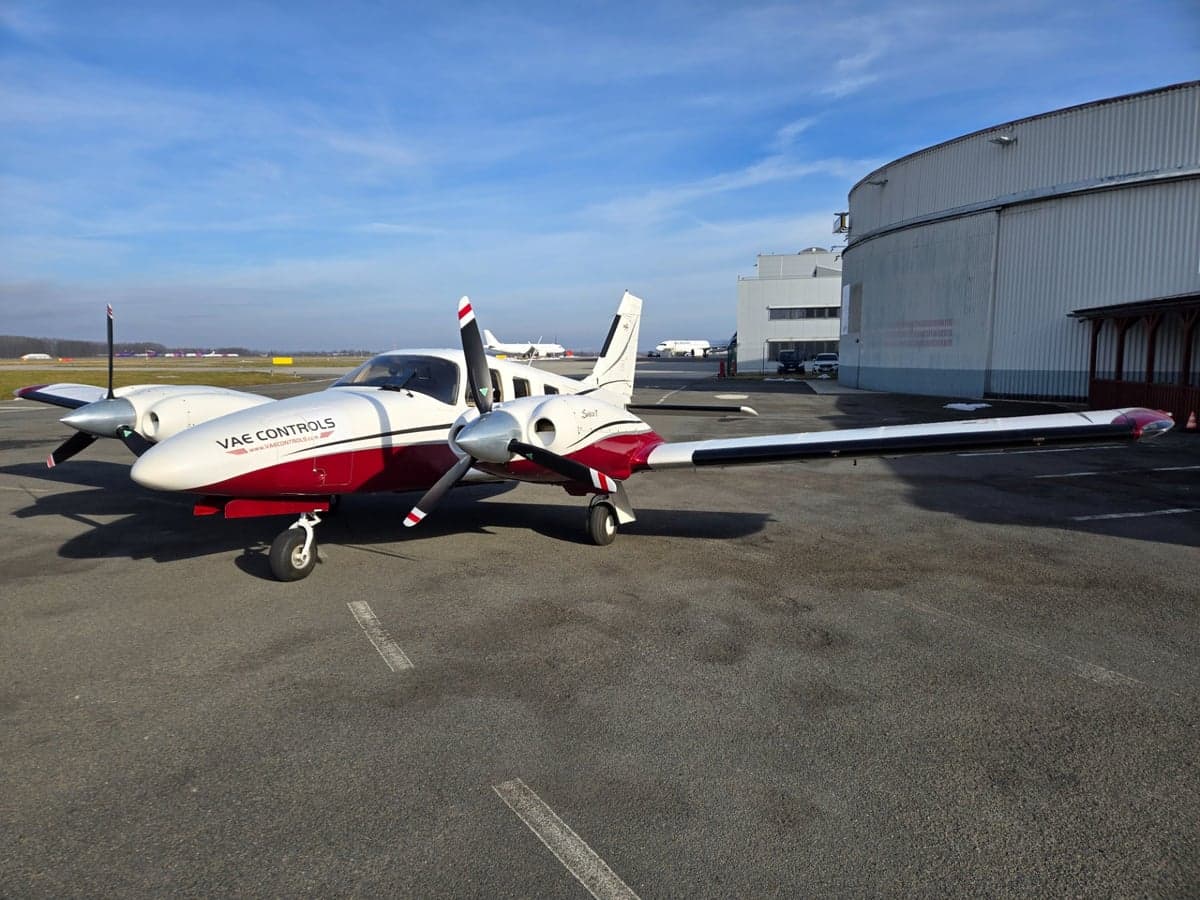 A Piper Seminole aircraft with a white and red paint scheme is parked on the tarmac.