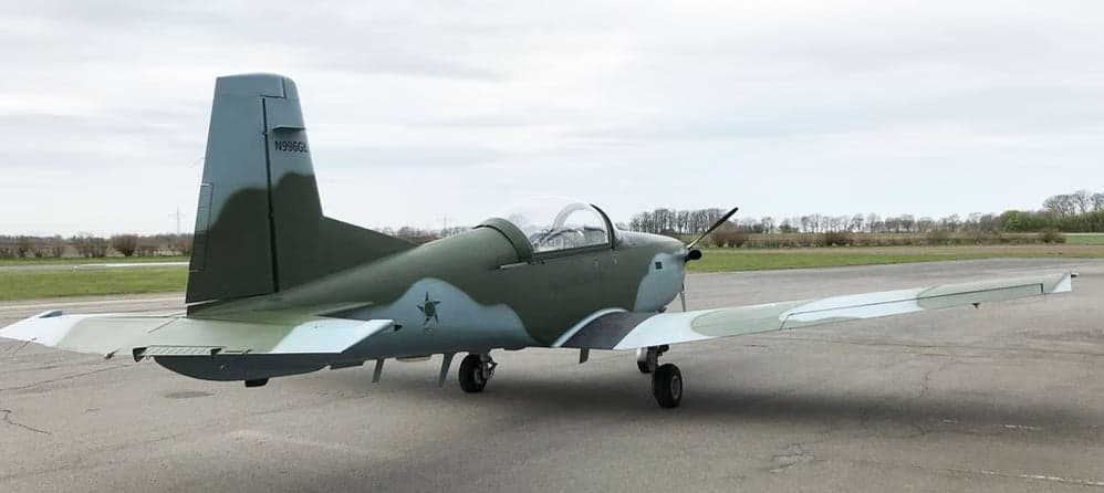 A Tucano aircraft with registration N996GL parked on the tarmac.