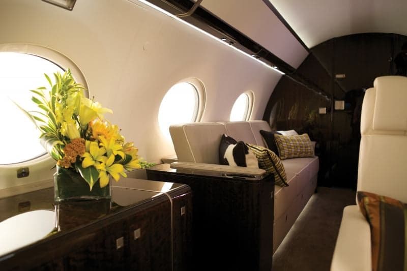 A view of the aircraft's interior with a table, flowers, and a tablet.