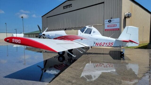 A Thrush 510G aircraft with a white and red paint scheme is parked on the tarmac.