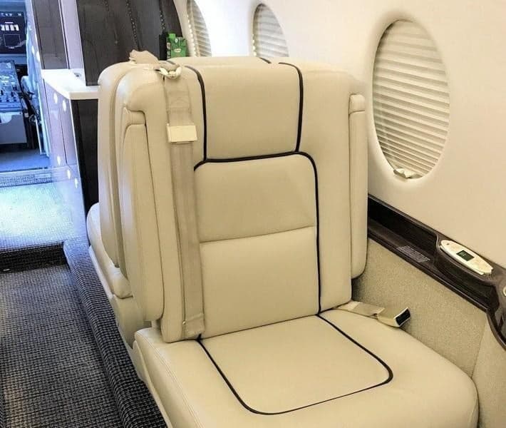 Close-up of a cream-colored leather seat inside the aircraft cabin.