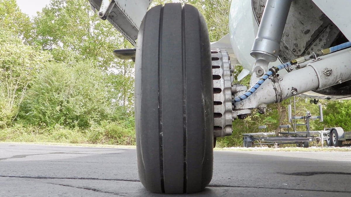 A close-up view of the main landing gear wheel of a Mitsubishi MU-2 aircraft.