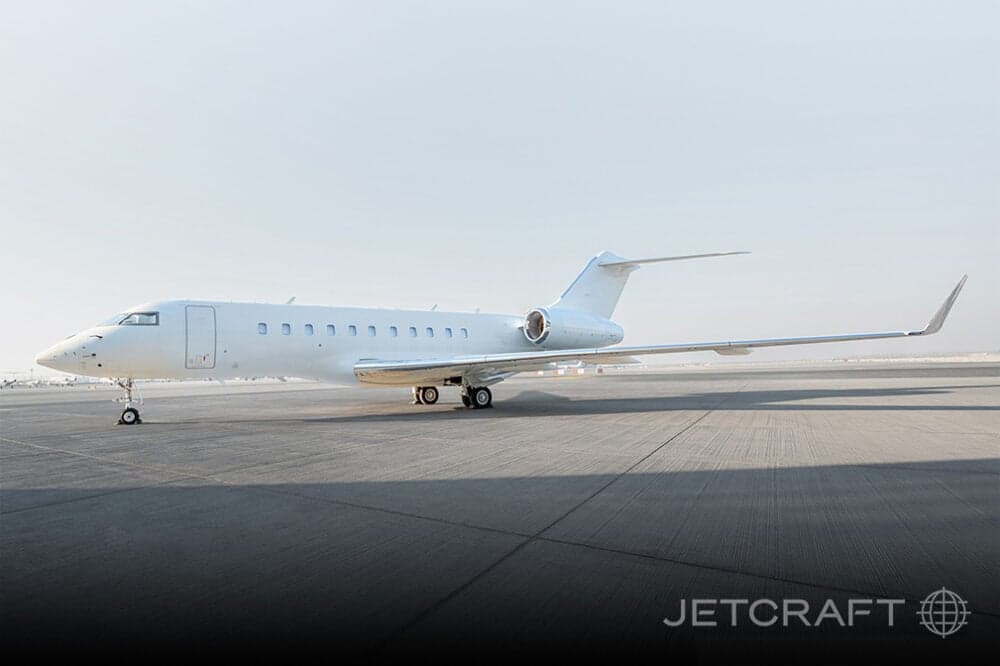 Side view of a white aircraft parked on the tarmac.