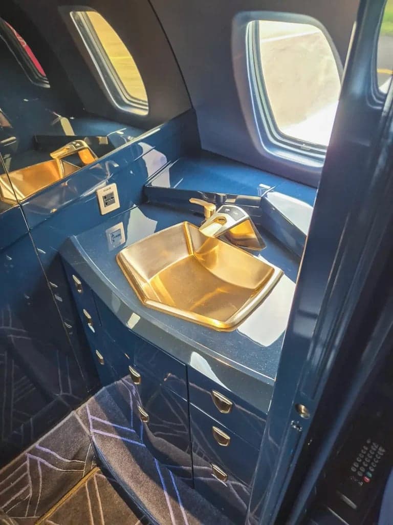 View of the aircraft's interior cabin with a gold sink.