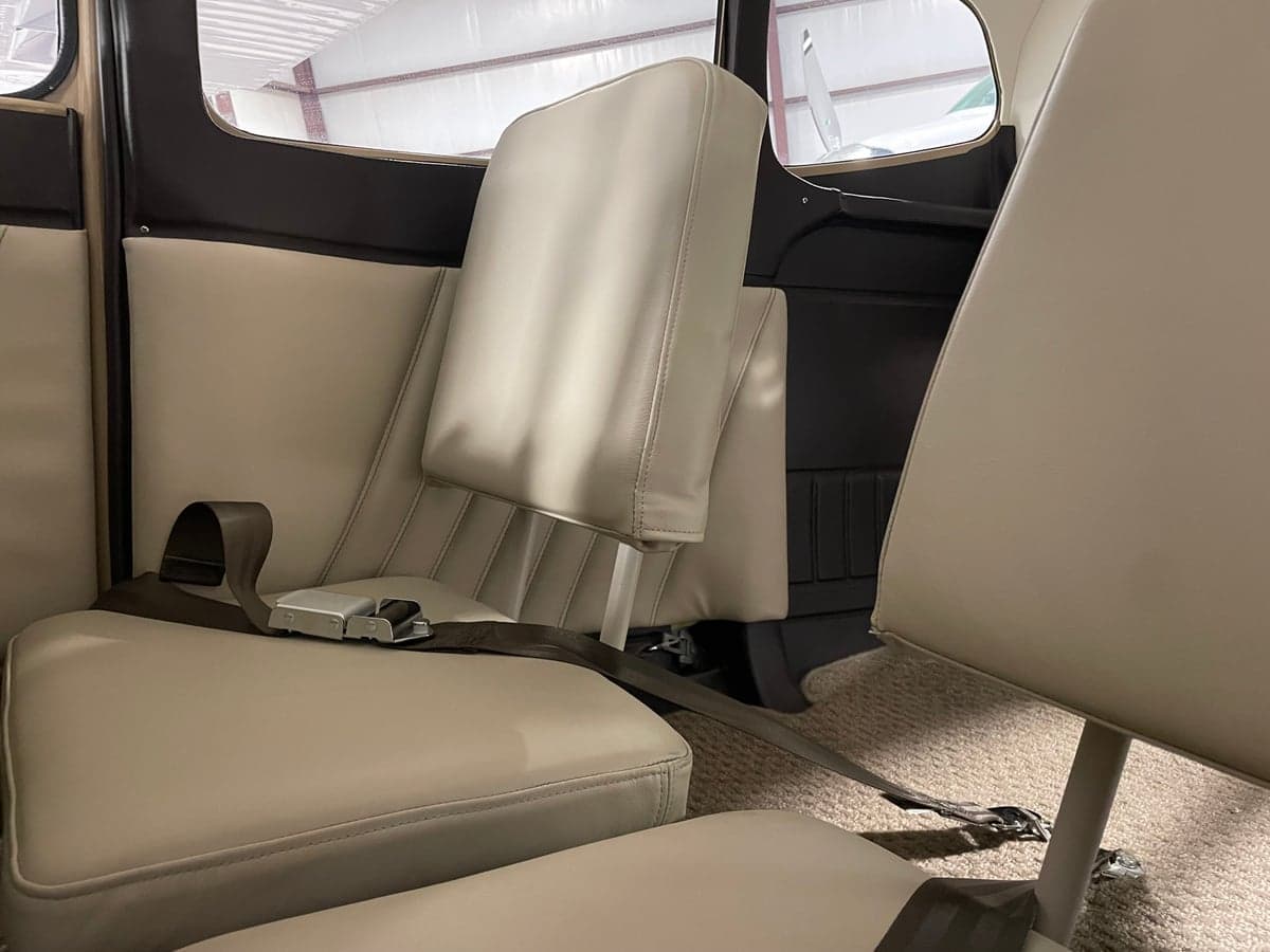 Rear seats of the Cessna 185 Skywagon with light colored upholstery.