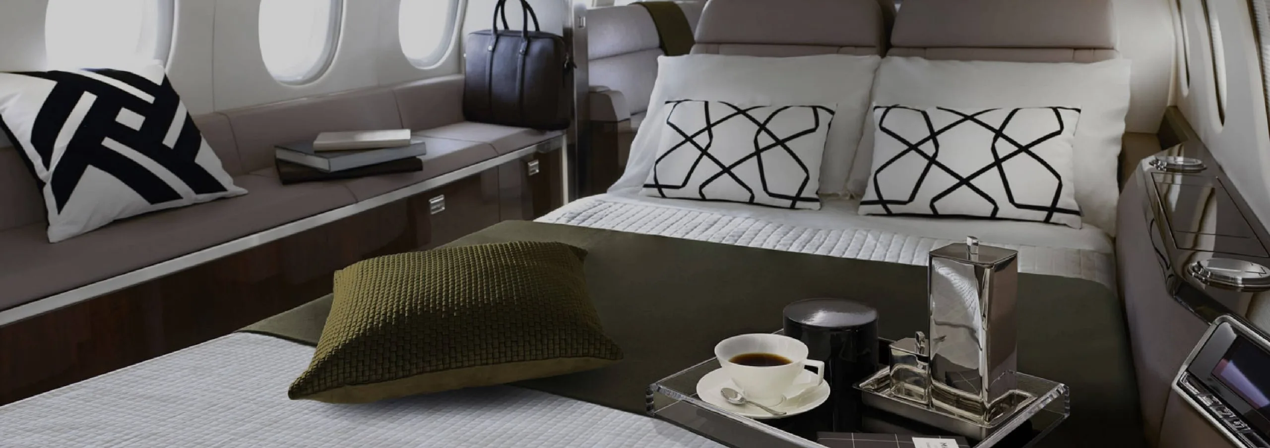 Luxurious aircraft interior with a bed and seating area.