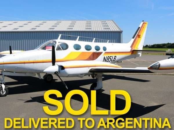 A Cessna 414 aircraft with yellow and orange stripes is marked as SOLD.
